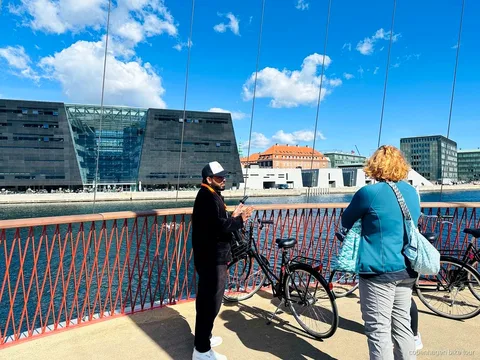 Guide expliquant l'histoire de Christiania à un petit groupe de cyclistes à Copenhague