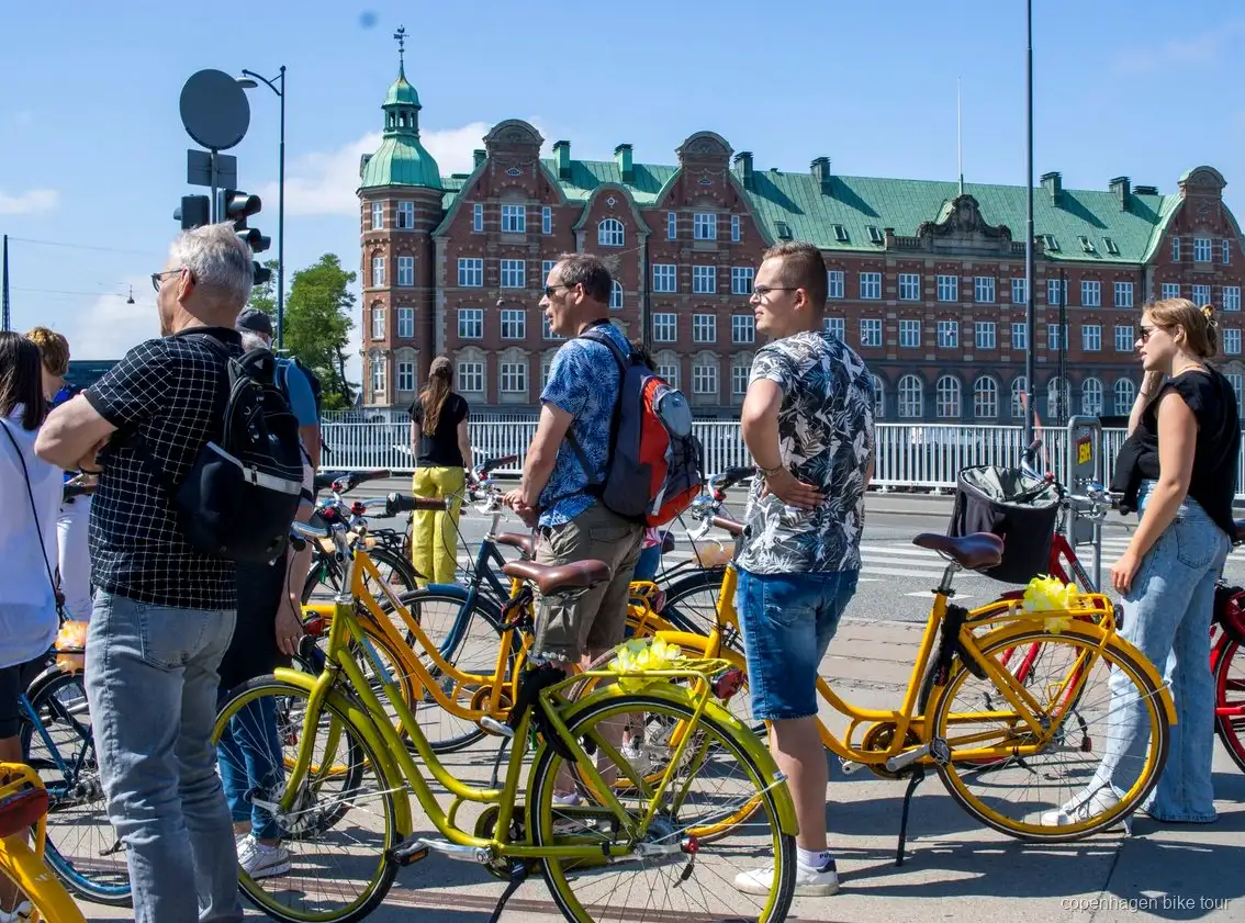 Cyclistes passant devant le palais de Christiansborg lors d'un circuit à vélo guidé à Copenhague