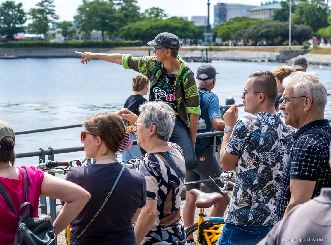 Local guide leading riders past Amalienborg Palace on a Copenhagen bike tour