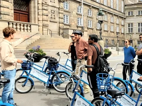 Riders passing Amalienborg Palace during a quick Copenhagen bike tour