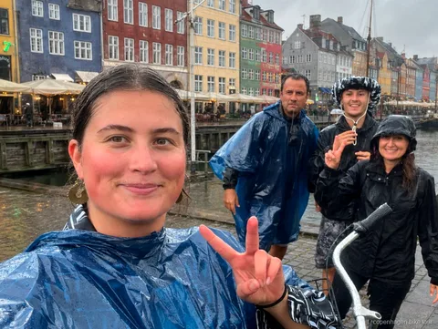 Liten grupp som cyklar in i Freetown Christiania på en guidad cykeltur i Köpenhamn