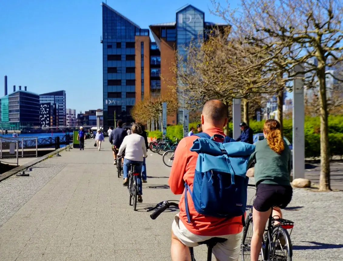Liten grupp som cyklar förbi Den Svarta Diamanten under en cykeltur i Köpenhamn