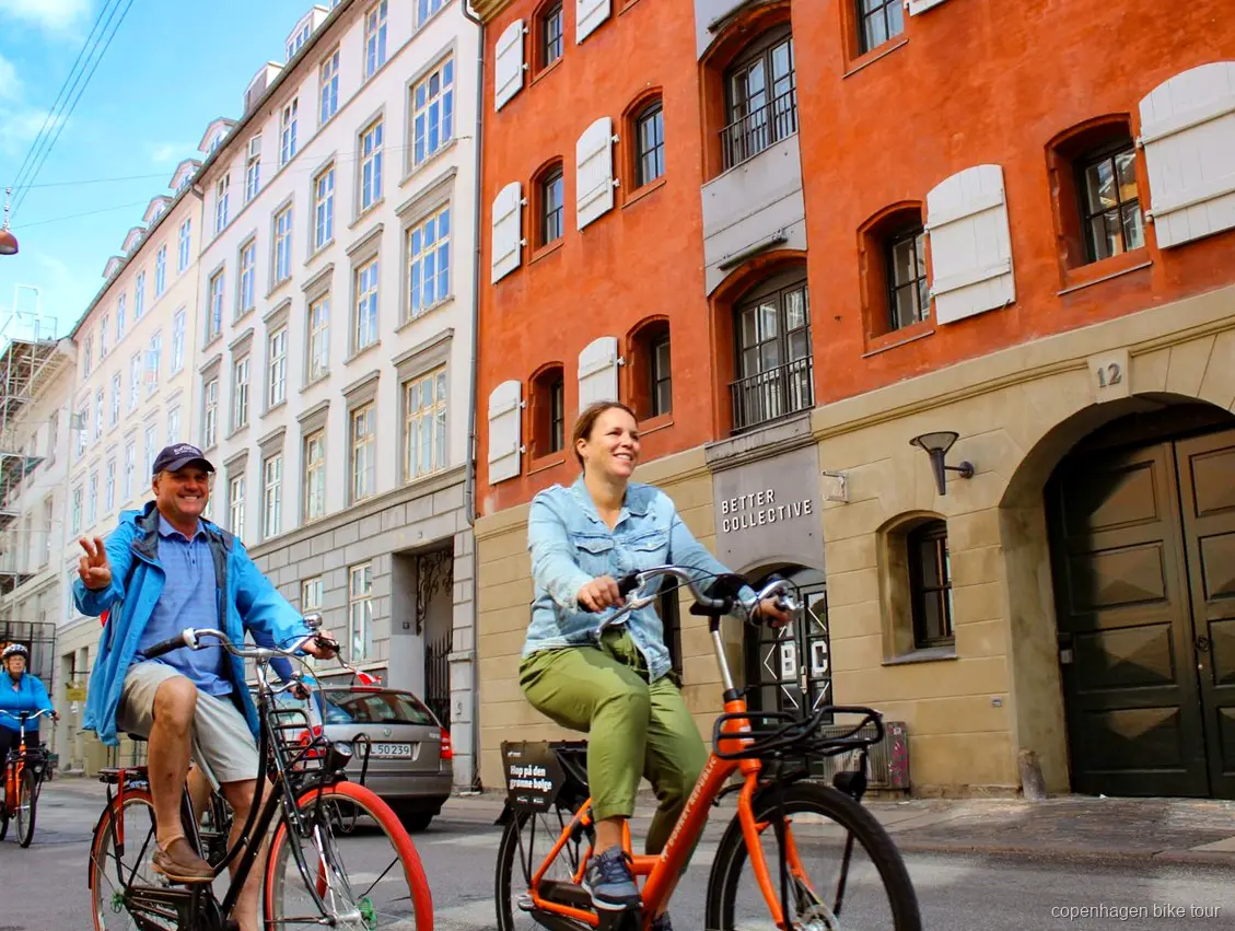 Cyklister längs hamnpromenaden nära Den Lilla Sjöjungfrun på en cykeltur i Köpenhamn