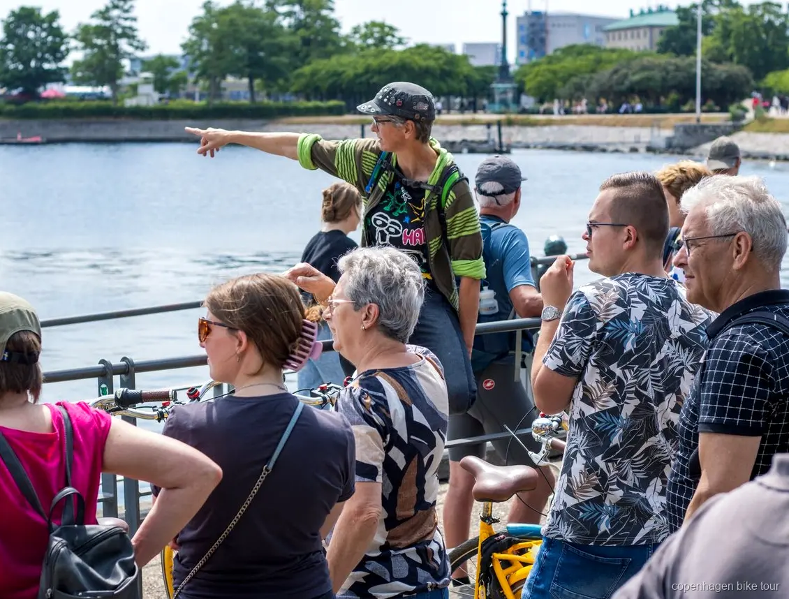 Lokal guide som leder cyklister förbi Amalienborgs slott på en cykeltur i Köpenhamn