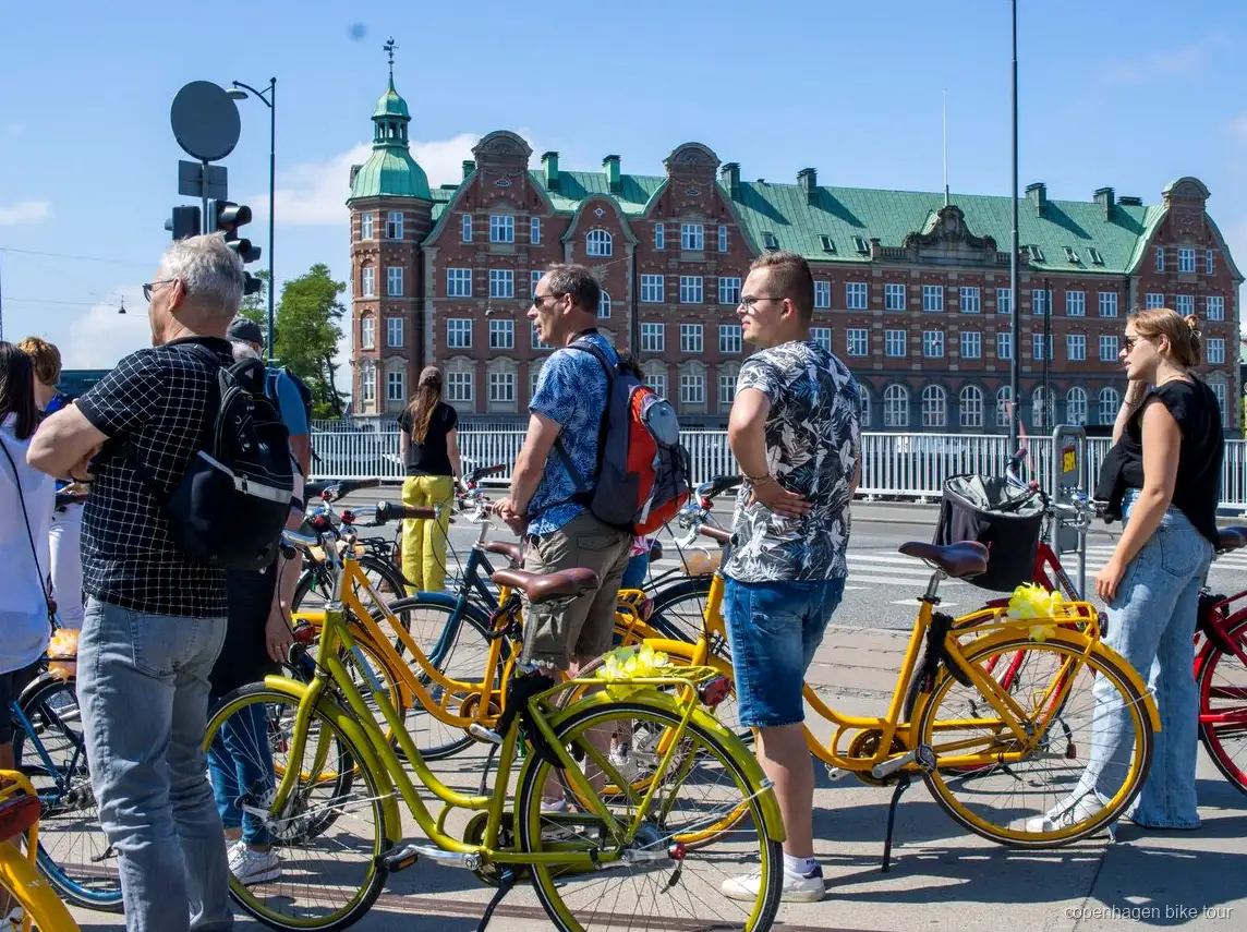Cyklister som passerar Christiansborgs slott på en guidad cykeltur i Köpenhamn