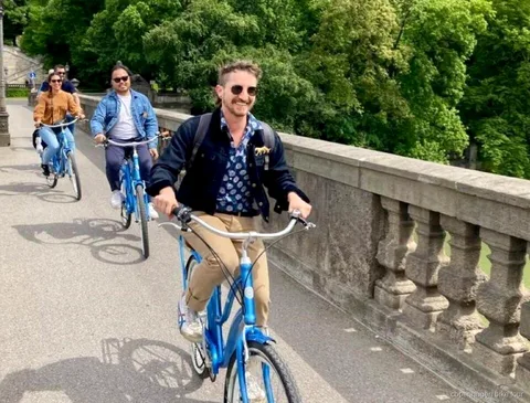 Cyklister der kører forbi Nyhavns farverige kanalhuse på en kort cykeltur i København