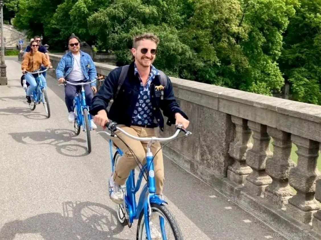 Cyklister som passerar Nyhavns färgglada kanalhus på en kort cykeltur i Köpenhamn