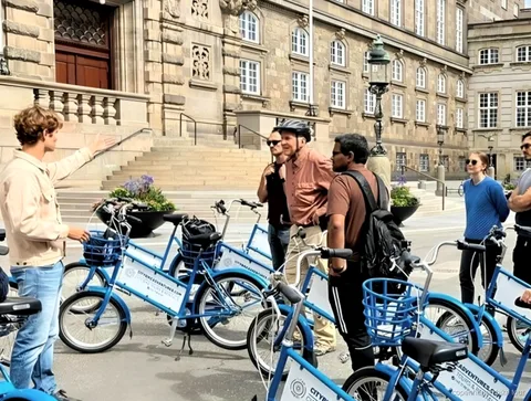 Cyklister som passerar Amalienborgs slott under en snabb cykeltur i Köpenhamn