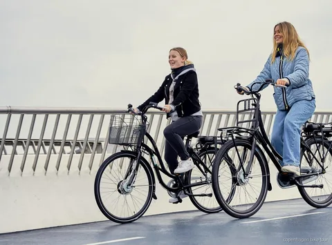 Rytter på en dansk designet elcykel nær Operaen i København