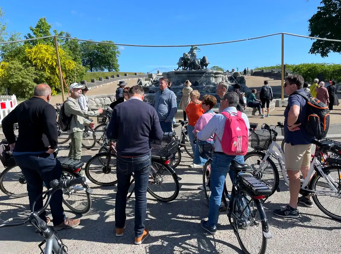 Ryttere der passerer Amalienborg Slot på en elcykeltur i København