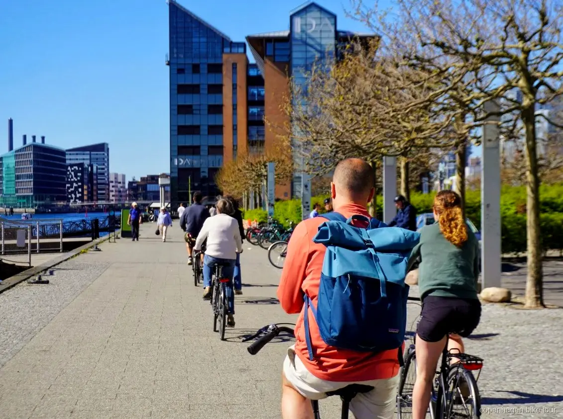 Kleine Gruppe fährt am Black Diamond vorbei auf einer Fahrradtour in Kopenhagen