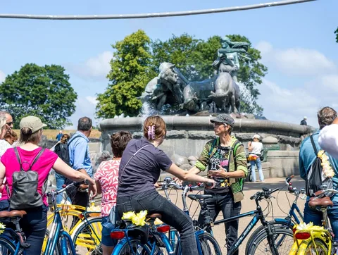 Gruppe fährt an den bunten Kanalhäusern vorbei auf der Fahrradtour zu den Sehenswürdigkeiten Kopenhagens