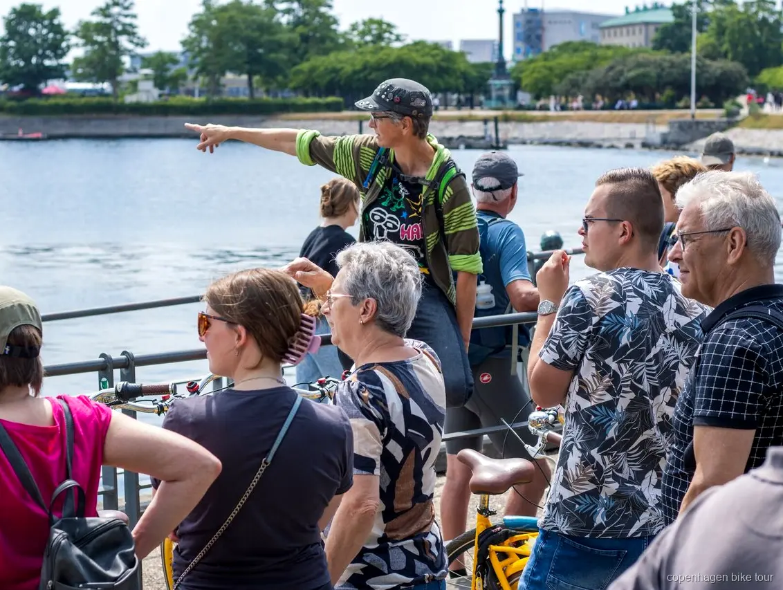 Lokale gids leidt fietsers langs Amalienborg Paleis op een fietstour in Kopenhagen