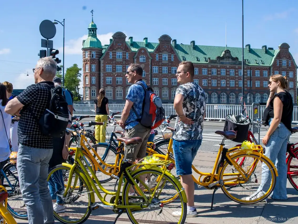 Fietsers passeren Christiansborg Paleis tijdens een begeleide fietstour in Kopenhagen