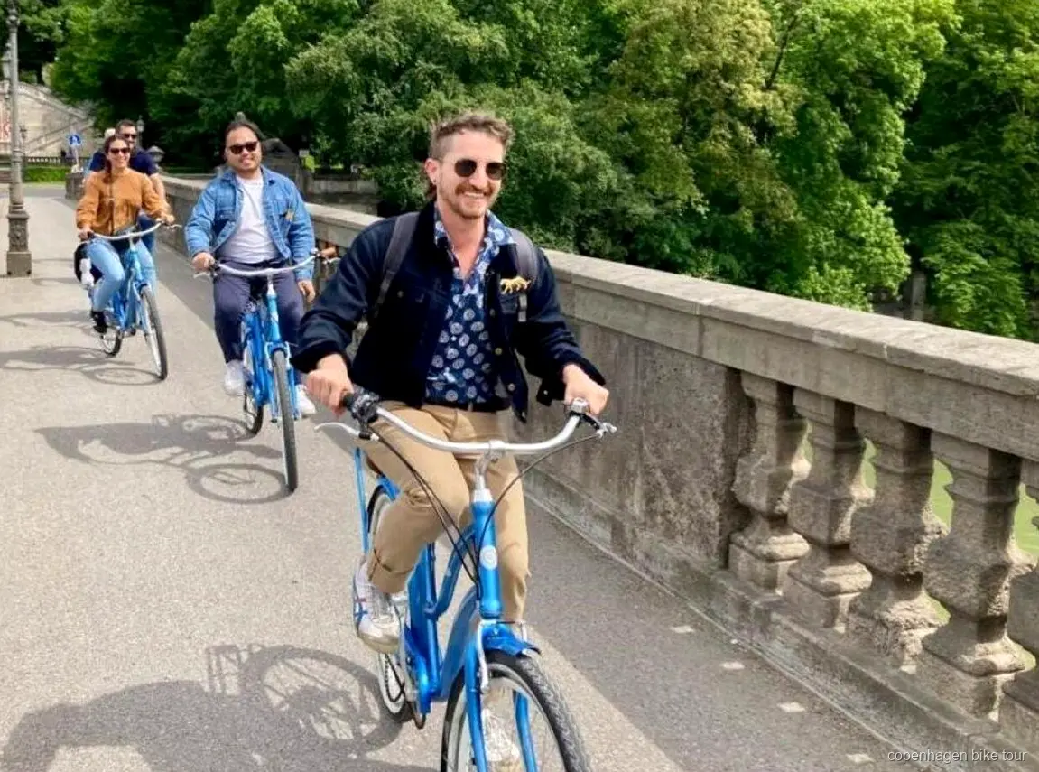 Fietsers rijden langs de kleurrijke grachtenhuizen van Nyhavn op een korte fietstour in Kopenhagen