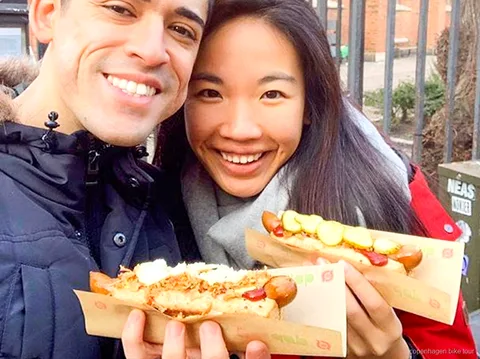 Guide der uddeler en dansk hotdogsmagning på en gastronomisk cykeltur i København