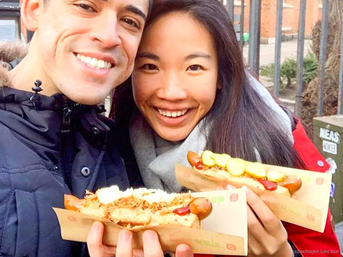 Guide der uddeler en dansk hotdogsmagning på en gastronomisk cykeltur i København