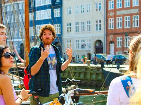 Ciclisti che passano davanti ai giardini del castello di Rosenborg durante un tour in bici guidato a Copenaghen