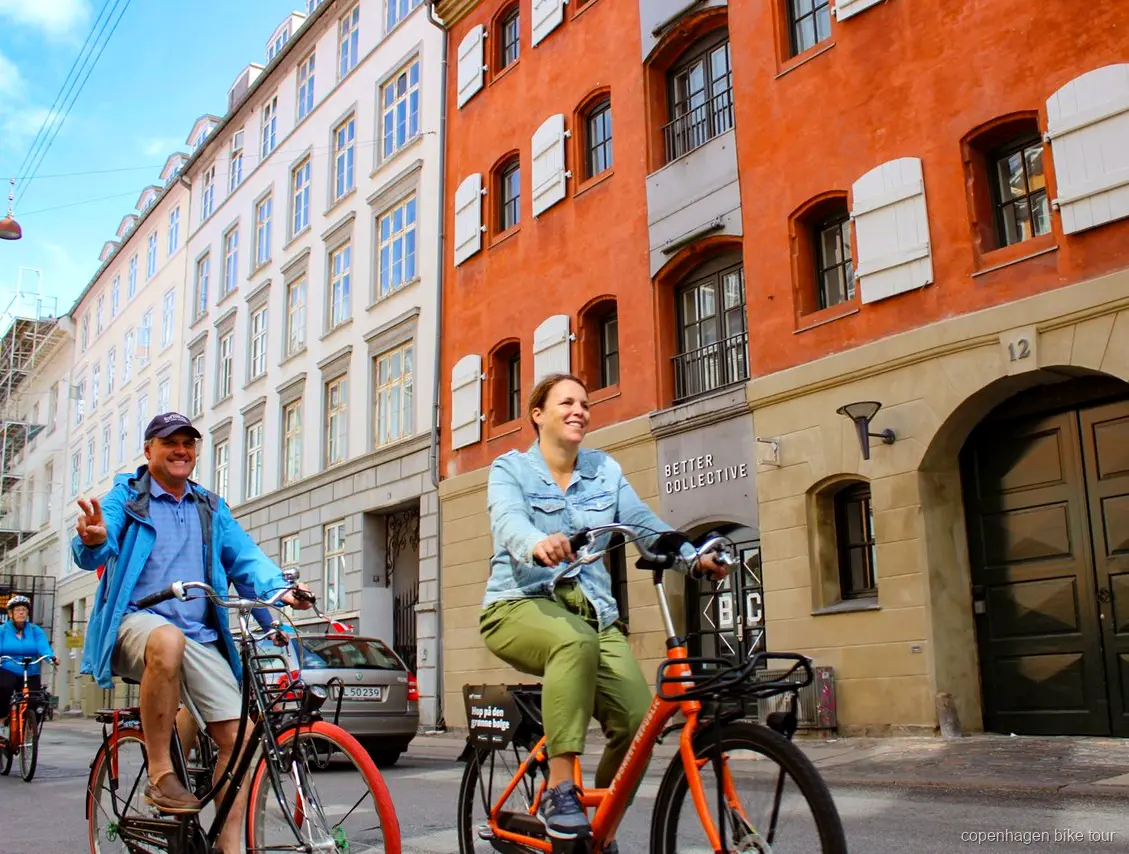 Ryttere langs havnepromenaden nær Den Lille Havfrue på en cykeltur i København