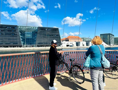 Guía explicando la historia de Christiania a un grupo reducido en bici en Copenhague