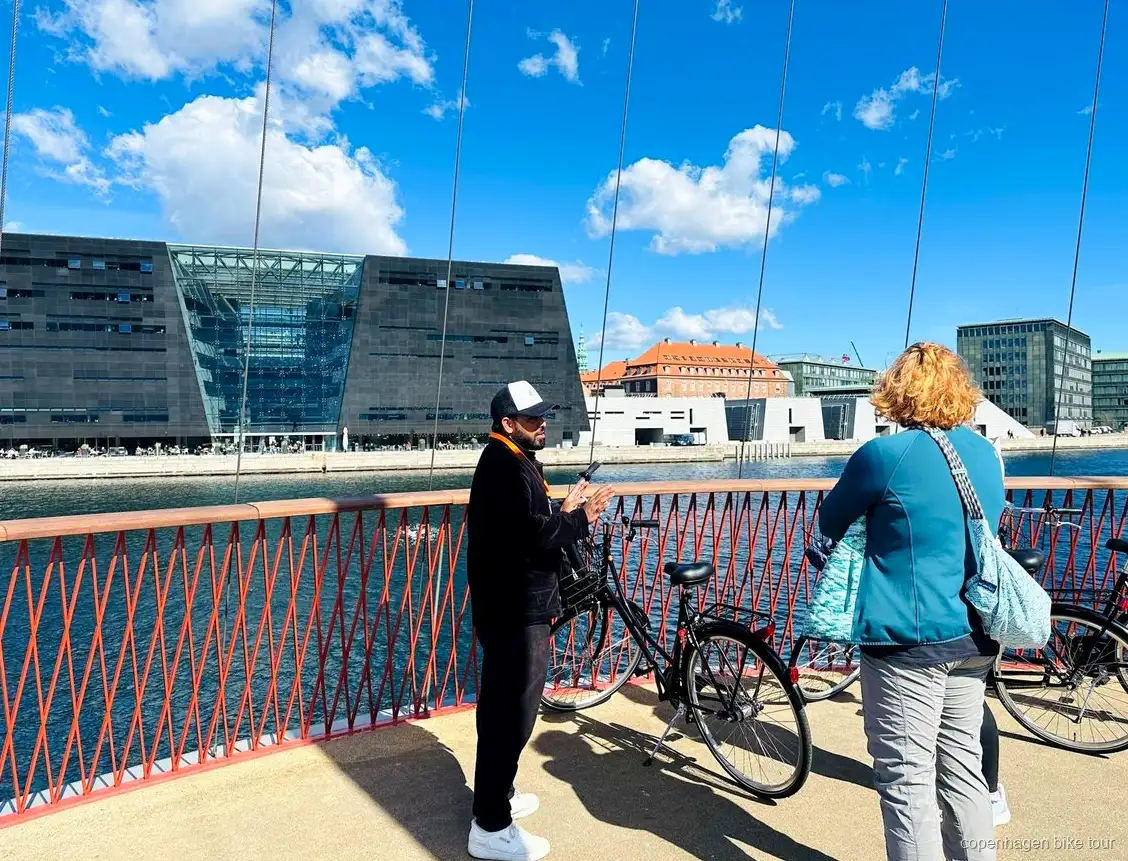 Guía explicando la historia de Christiania a un grupo reducido en bici en Copenhague