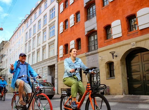 Ciclistas por el paseo del puerto cerca de la Sirenita en un tour en bici por Copenhague