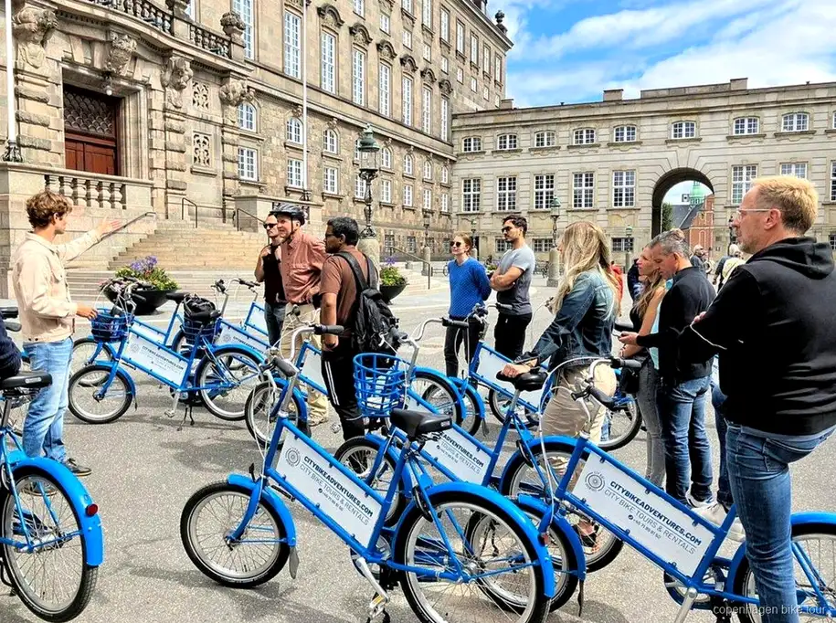 Guía señalando la biblioteca Black Diamond durante un tour en bici por Copenhague