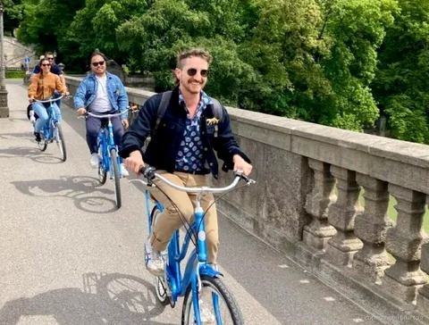 Ciclistas pasando por las casas de colores del canal de Nyhavn en un tour en bici corto por Copenhague