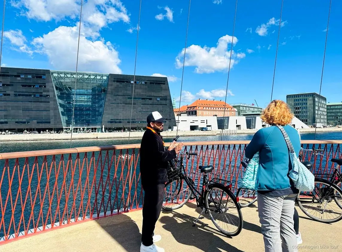 Guida che racconta la storia di Christiania a un piccolo gruppo di ciclisti a Copenaghen
