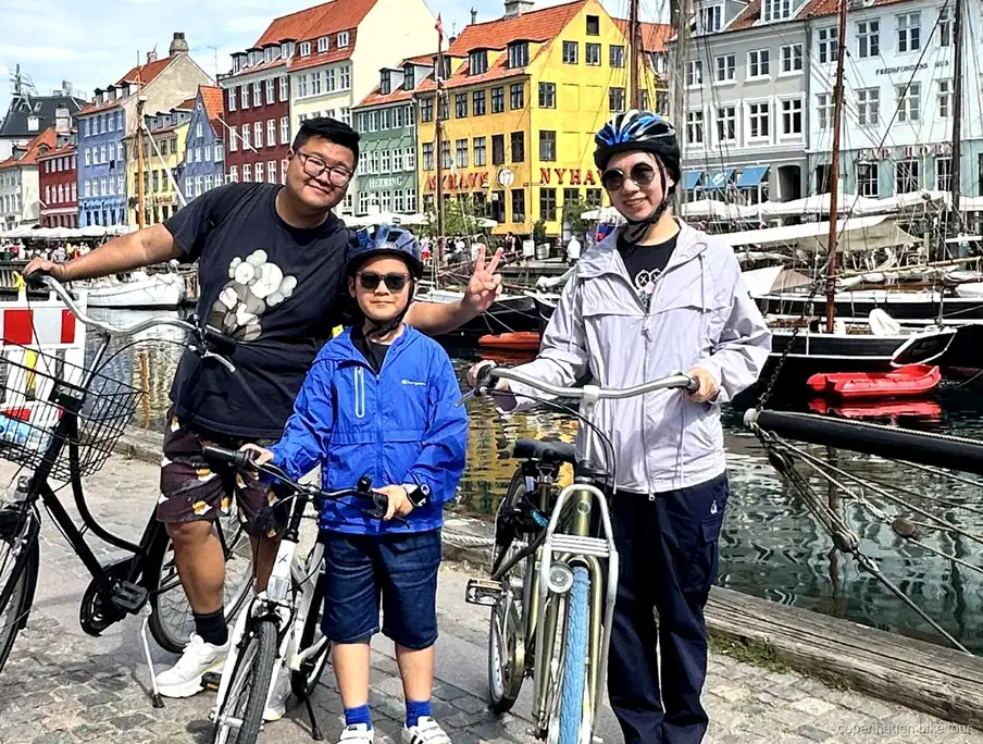Ciclisti al palazzo di Amalienborg durante un tour in bici a Copenaghen con visita a Christiania