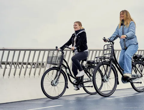 Ciclista su una e-bike di design danese vicino al teatro dell'opera di Copenaghen