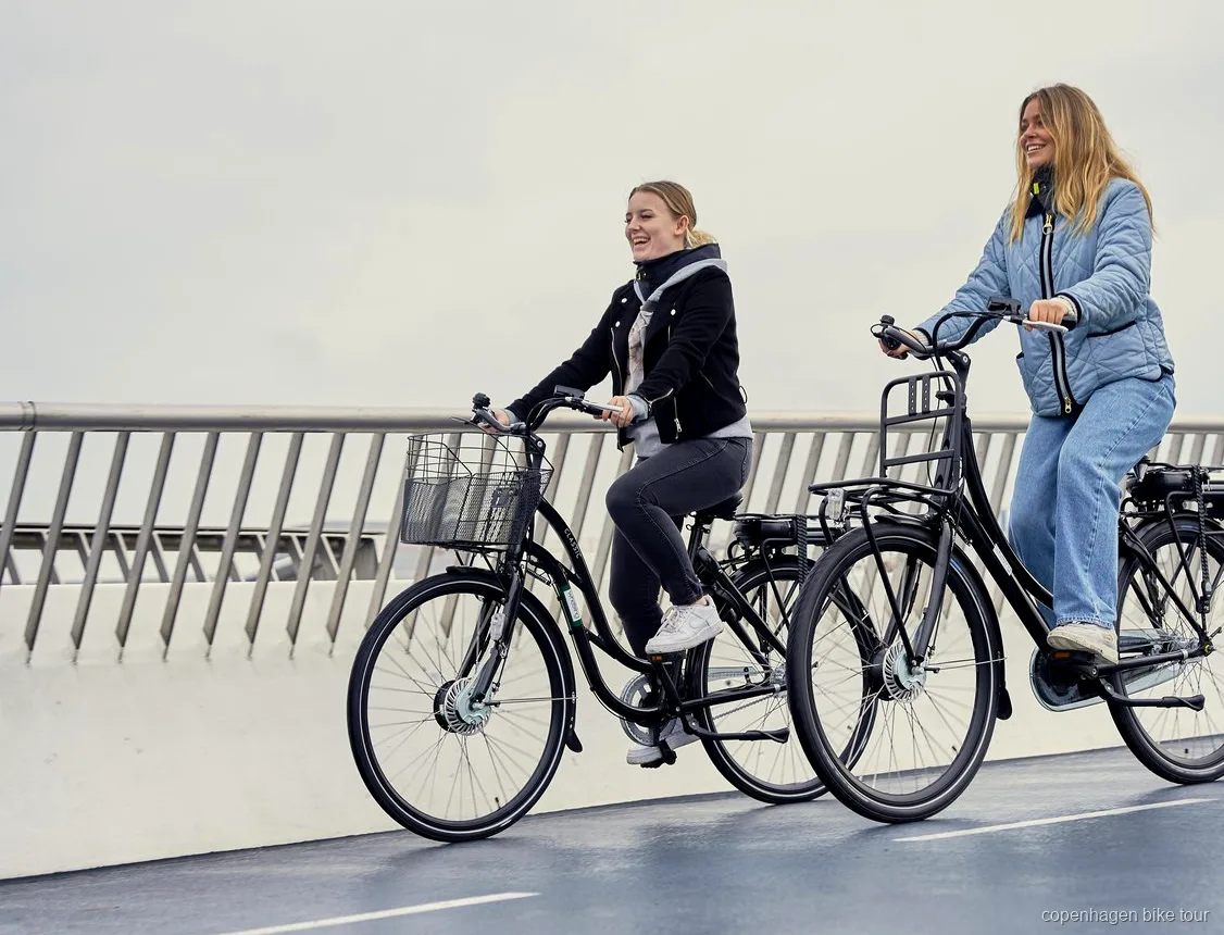 Ciclista su una e-bike di design danese vicino al teatro dell'opera di Copenaghen